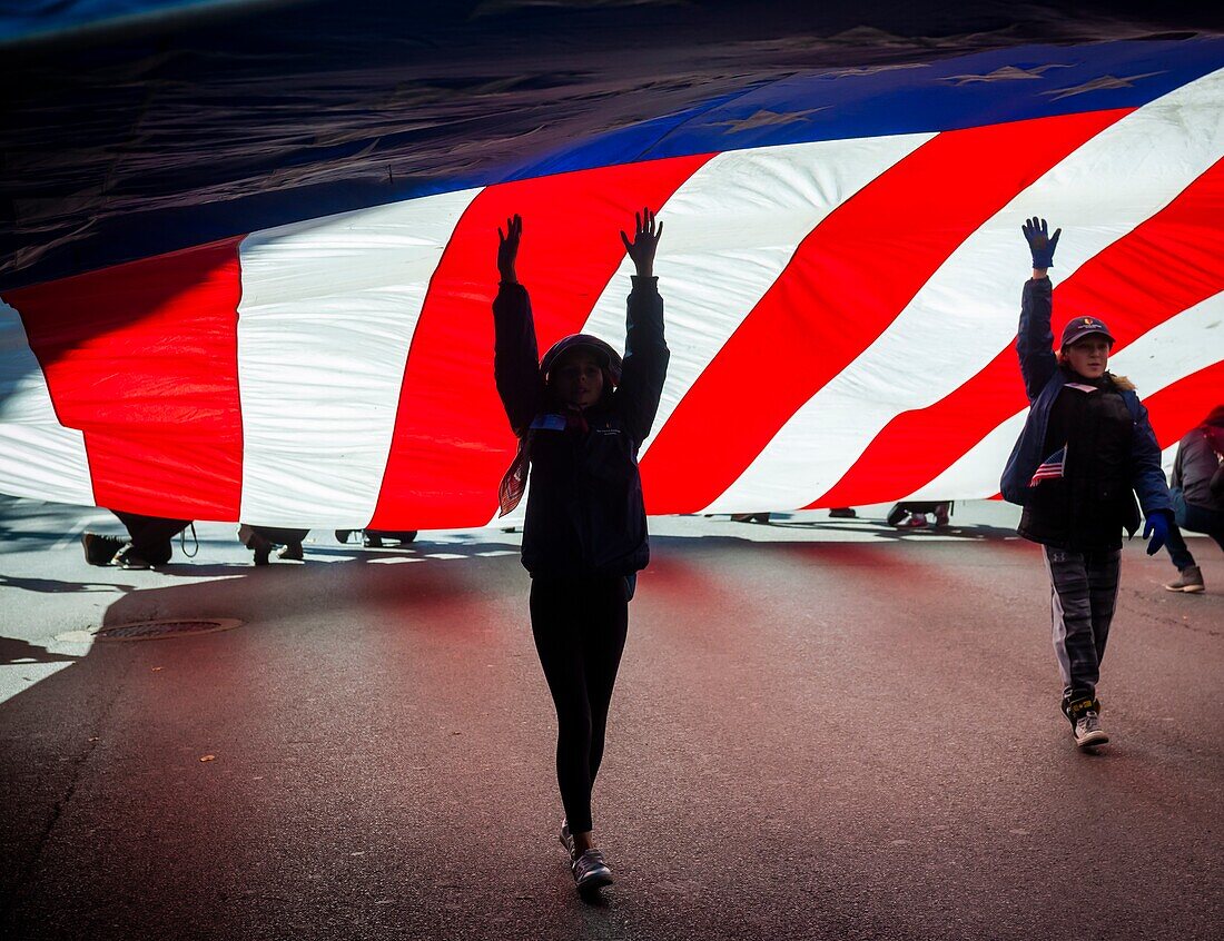 Eine riesige amerikanische Flagge wird während der Veterans Day Parade am Sonntag, dem 11. November 2018, auf der Fifth Avenue in New York getragen. Ursprünglich als Tag des Waffenstillstands bekannt, erinnert der Feiertag dieses Jahr an den 100. Jahrestag des Endes des Ersten Weltkriegs. In der elften Stunde des elften Tages des elften Monats verstummten die Waffen im Jahr 1918, was das Ende des Ersten Weltkriegs kennzeichnete. Der Feiertag wurde auf alle amerikanischen Soldaten aus allen Kriegen erweitert.
