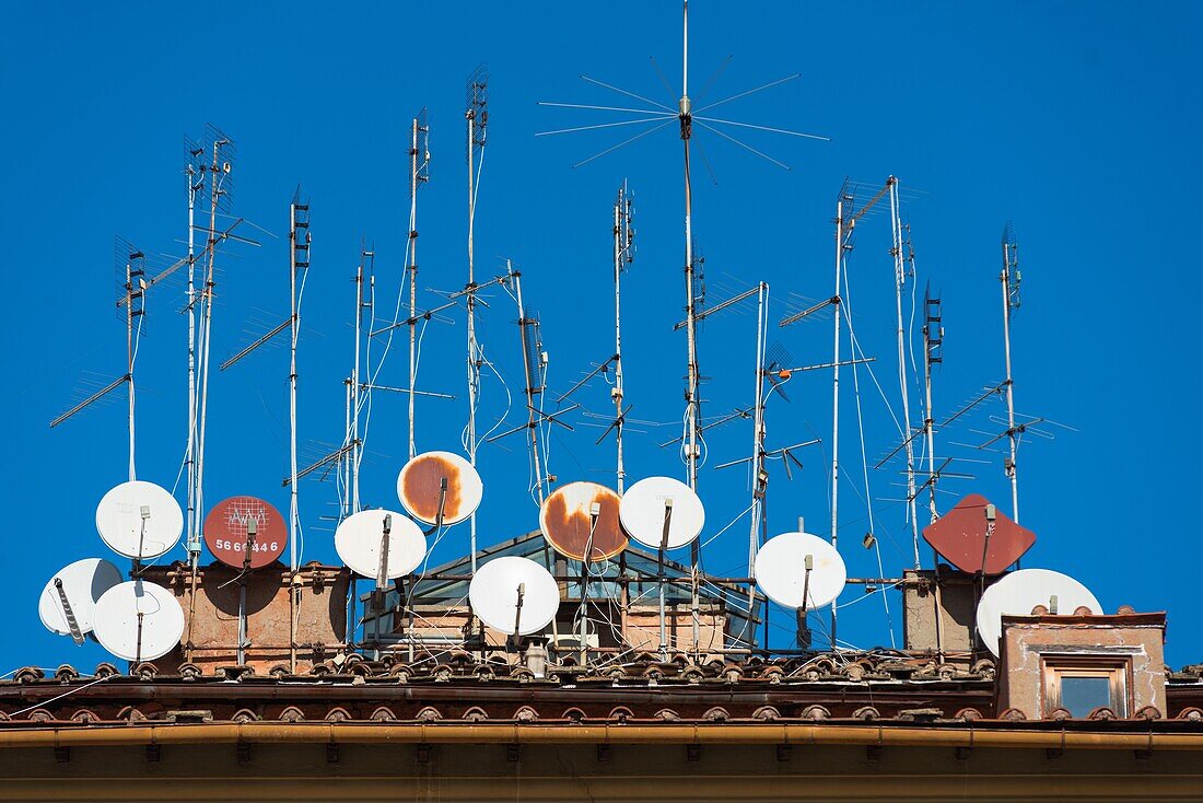 Rostige alte Antennen und Satellitenschüsseln an einem Gebäude in Trastevere, Rom, Italien.