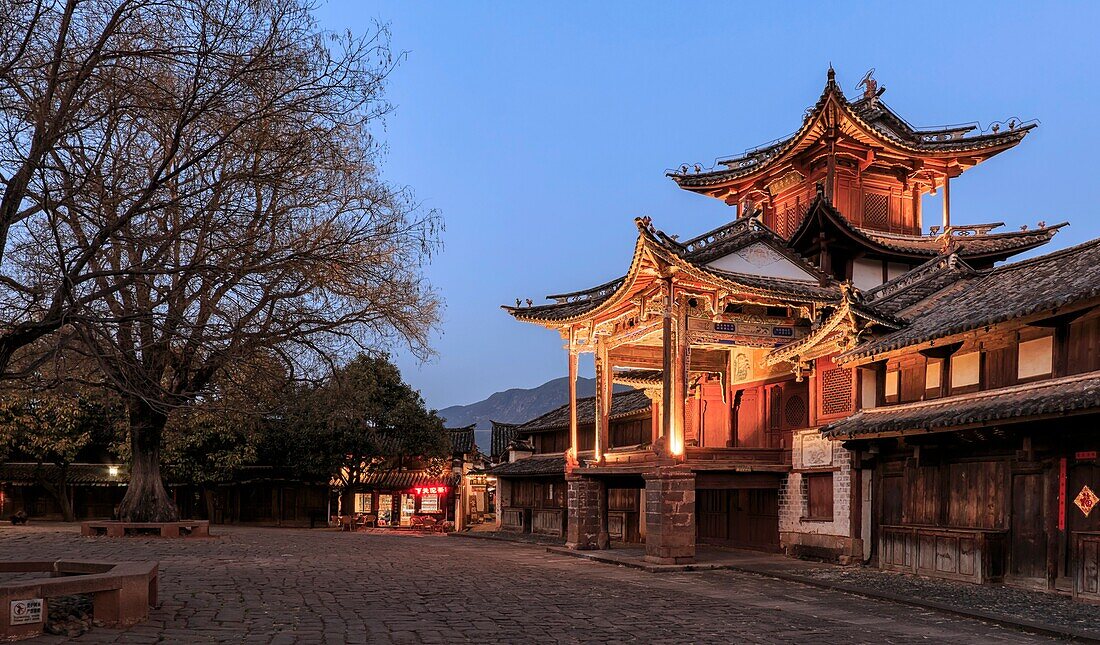 Shaxi,China - February 21,2019: Central square of Shaxi old town at sunset with the old theater illuminated.