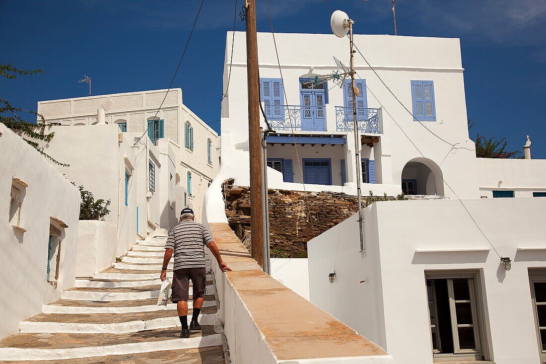 Lokale Person, die die Treppe im Dorf Artemonas mit den traditionellen Kykladenhäusern im Hintergrund hinaufgeht, Insel Sifnos, Kykladen, griechische Inseln, Griechenland, Europa