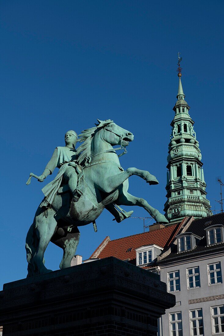 Equestrian statue of Bishop Absalon (founder of Copenhagen),with spire of St Kunsthallen Nikolaj Church,Højbro Plads square,Copenhagen,Denmark.
