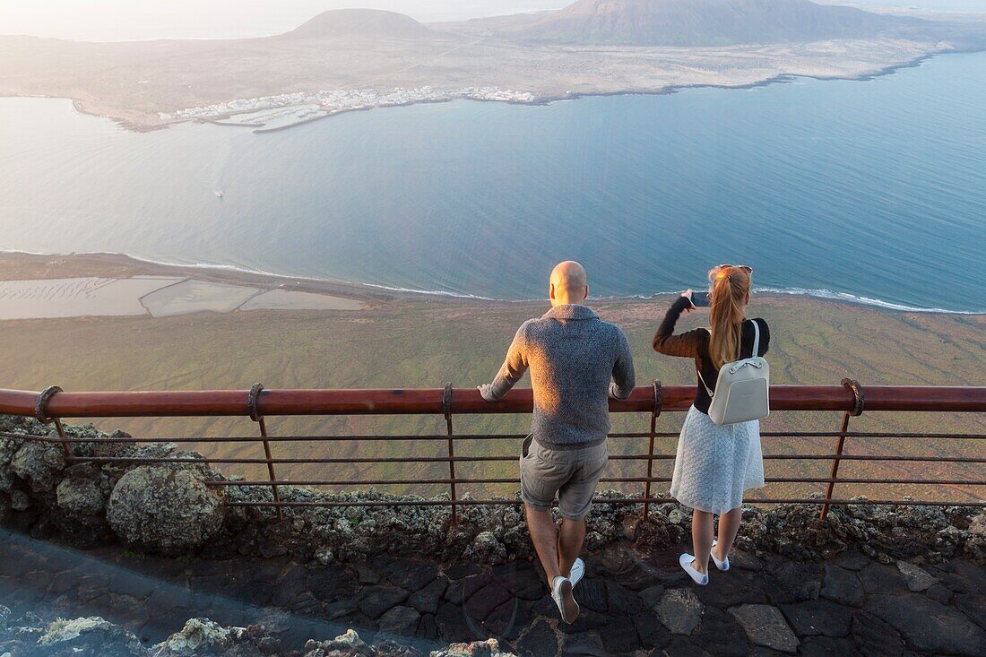 Young couple watching the abyss. Mirador del Rio,Lanzarote. Spain.