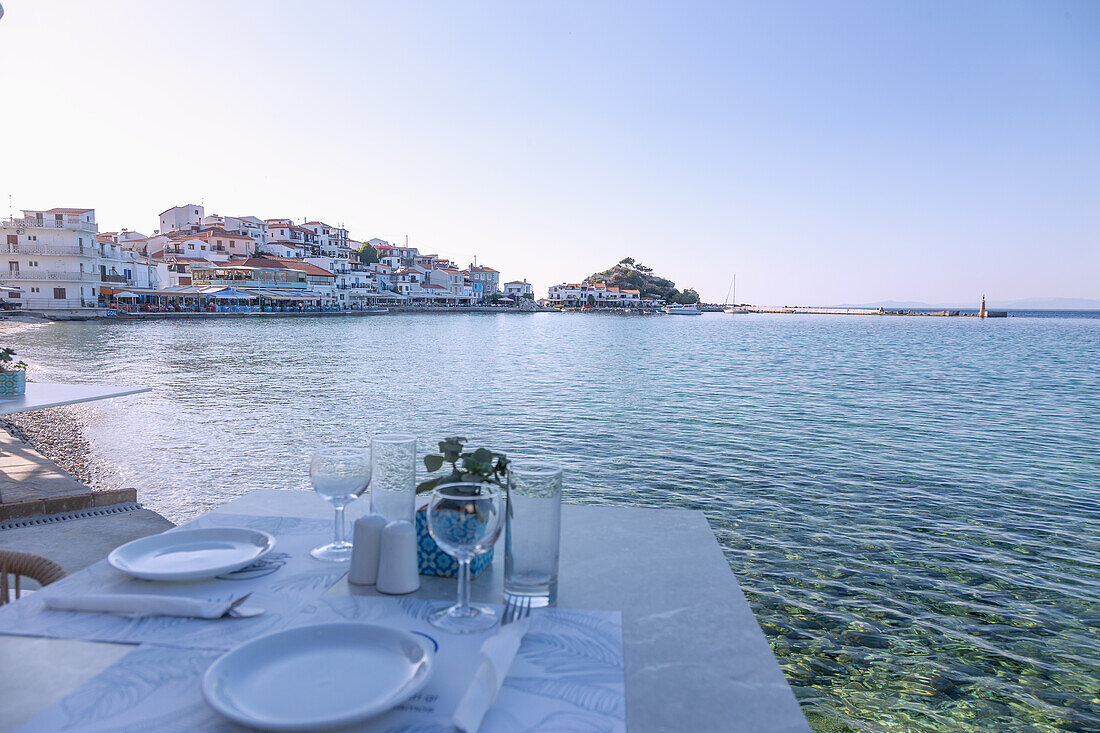 Kokkari, Altstadt mit Tavernen und gedecktem Tisch am Hafen auf der Insel Samos in Griechenland