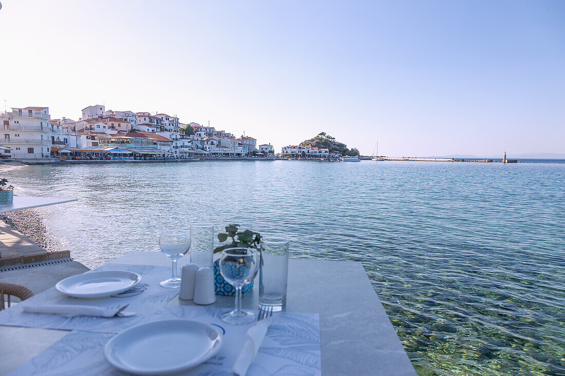 Kokkari, old town with taverns and a set table at the harbor on the island of Samos in Greece