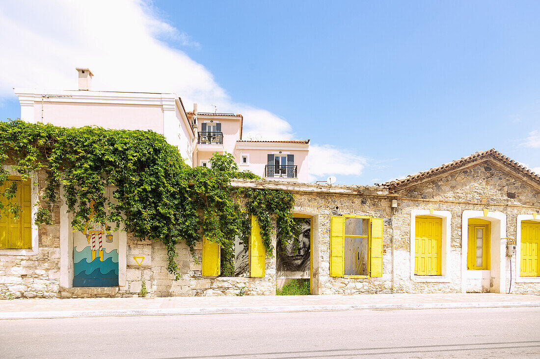 Neo Karlovassi, Kon/nou Kanari street towards the port with street art by b. This is my world and Simple G on Samos island in Greece