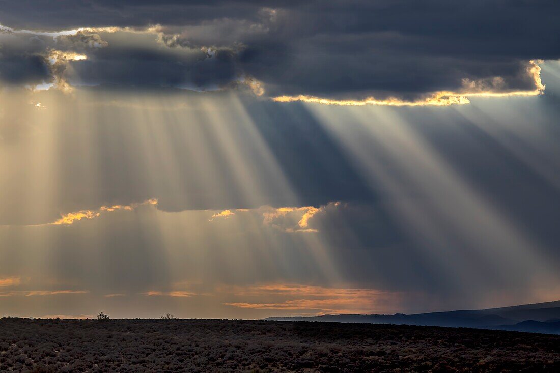 Stürmische Himmel ziehen durch die Landschaft von Süd-Utah und produzieren Sonnenstrahlen bei Sonnenuntergang.