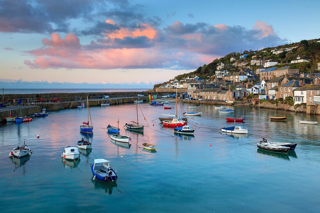 Der malerische Hafen von Mousehole auf der Westseite der Mount's Bay in Cornwall. Das Bild wurde bei Sonnenaufgang an einem stillen Morgen Ende April aufgenommen.