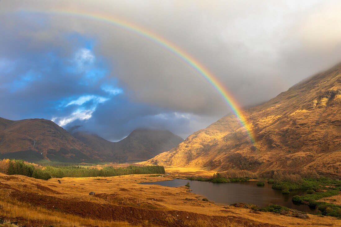 Ein Regenbogen über Glen Etive in Schottland, aufgenommen während eines Sonnenstrahls an einem Nachmittag Anfang November.