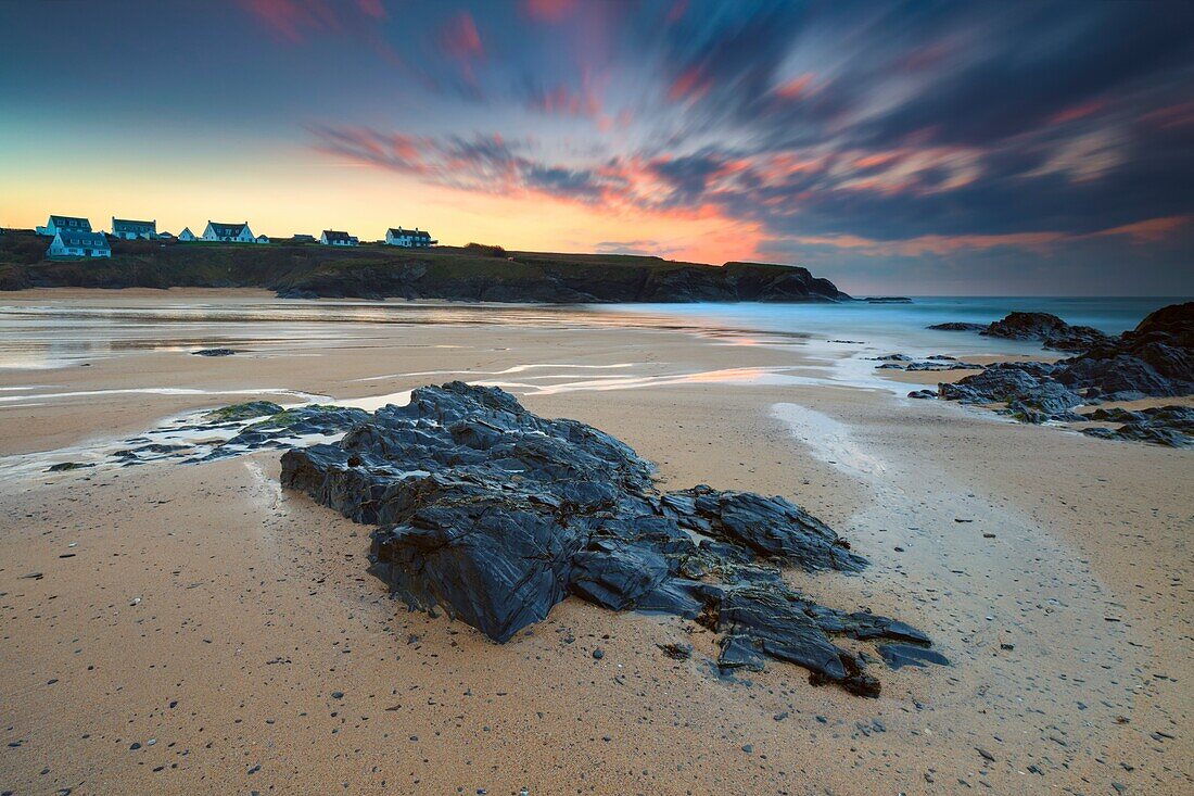 Sonnenuntergang am Strand von Treyarnon Bay an der Nordküste von Cornwall Mitte Januar. Eine Langzeitbelichtung wurde verwendet, um die Bewegung in den Wolken und im Wasser zu verwischen.