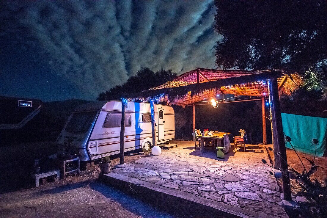 Leuchtender Campingplatz unter dem Nachthimmel, Tarifa, Cádiz, Andalusien, Spanien.