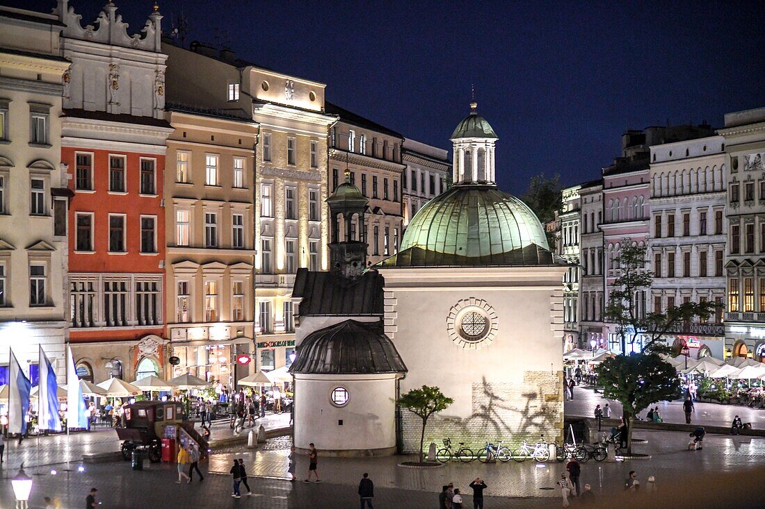 Lichter beleuchteten das Äußere der Kirche St. Adalbert (Kirche St. Wojciech) nachts in der Mitte des Hauptmarktplatzes in Krakau Altstadt, Woiwodschaft Kleinpolen, Polen.