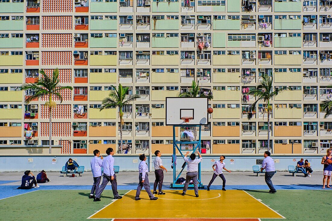 China,Hongkong,Kowloon Island,dicht überfüllte Wohnhäuser,Studenten, die Basketball spielen.