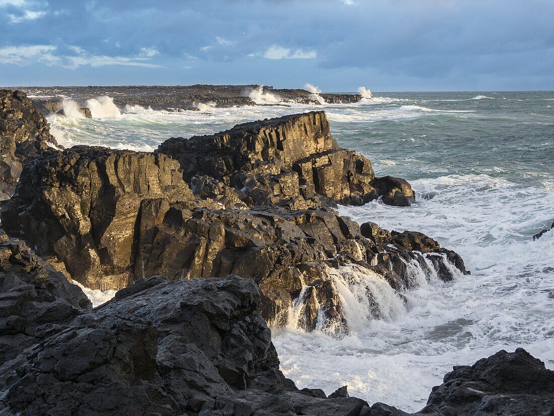 Küste bei Brimketill bei stürmischem Wetter bei Sonnenuntergang. Die Küste des Nordatlantiks auf der Halbinsel Reykjanes im Winter. Nordeuropa, Skandinavien, Island, Februar.
