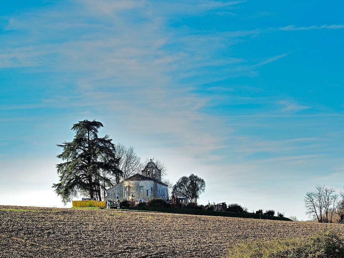 Leerer Acker und Kirche von Saint-Macaire, Departement Lot-et-Garonne, Neu-Aquitaine, Frankreich.