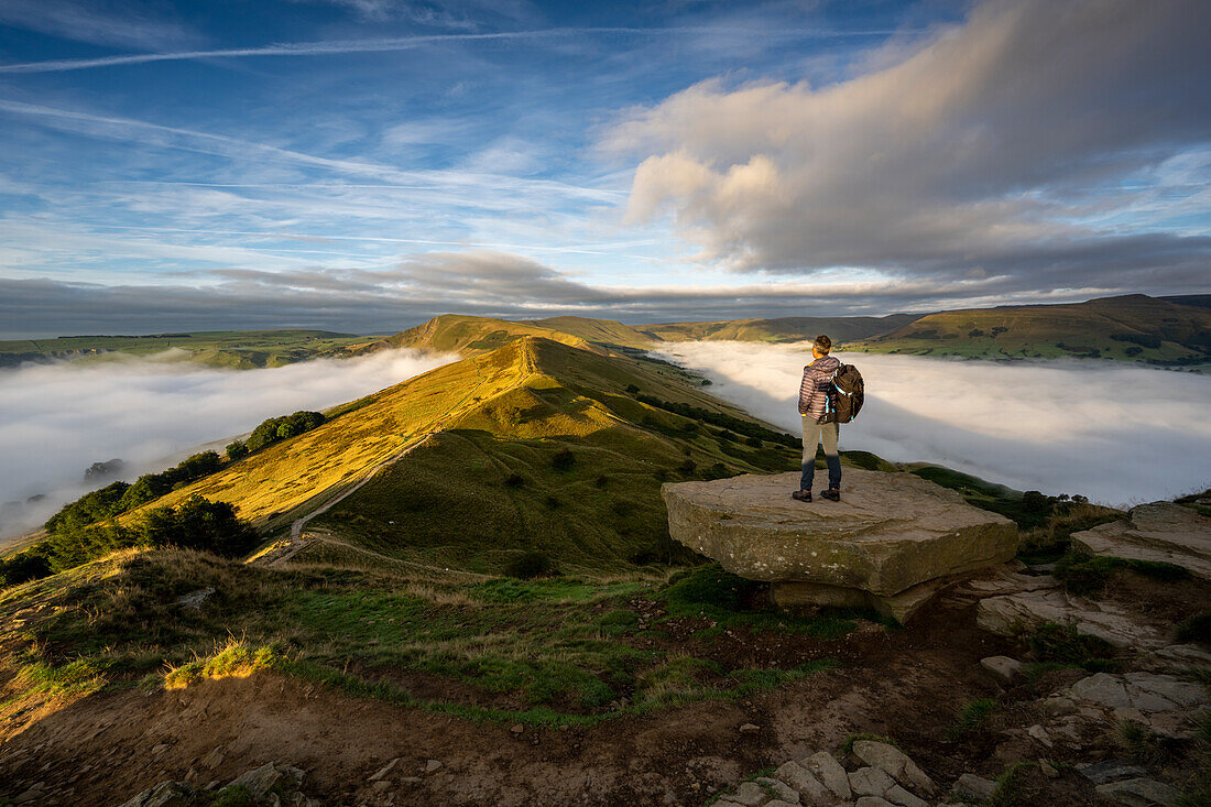 A man looking across The Great Ridge during a cloud inversion with view of Mam Tor, Hope Valley, Peak District, Derbyshire, England, United Kingdom, Europe