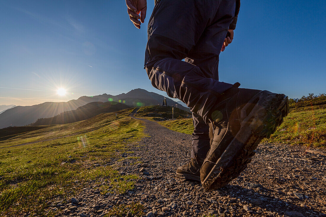 Wanderer läuft dem Sonnenaufgang entgegen, Europäischer Fernwanderweg E5, Krahberg, Berg Venet, Zams, Tirol, Österreich