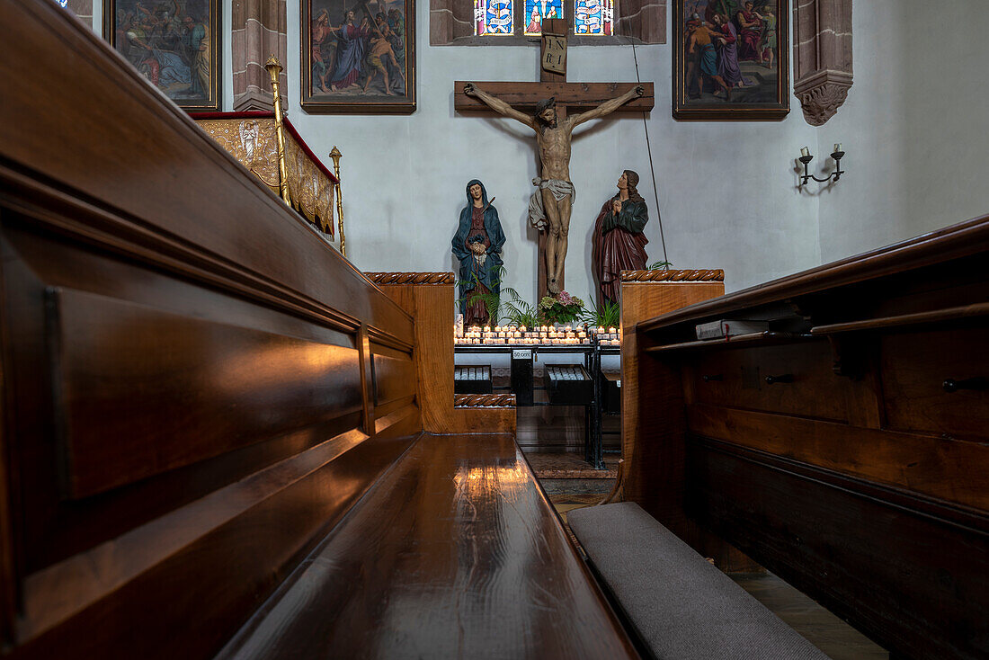 Jesus on the cross, candles, pew, parish church of St. Nicholas, Meran, South Tyrol, Alto Adige, Italy