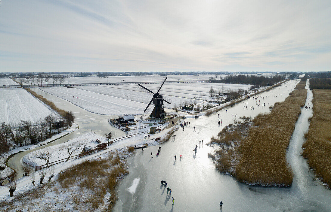 Nederland, Utrecht, Lexmond, Luftaufnahme von Menschen, die in Landschaft Eislaufen