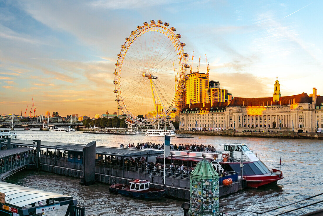 UK, London, Tourboat on River Thames and London Eye at sunset