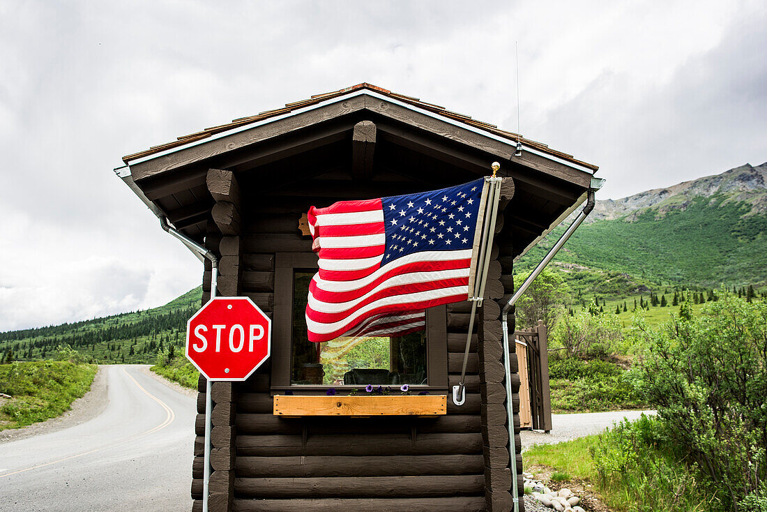USA, Alaska, amerikanische Flagge und Stoppschild an der Kabine