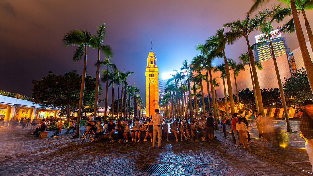 Group of people sitting near Kowloon Clock Tower, Tsim Sha Tsui