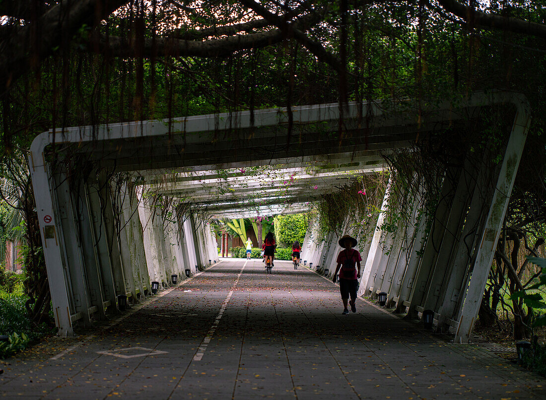 Men and women riding bicycle and walking under tunnel in Taiwan