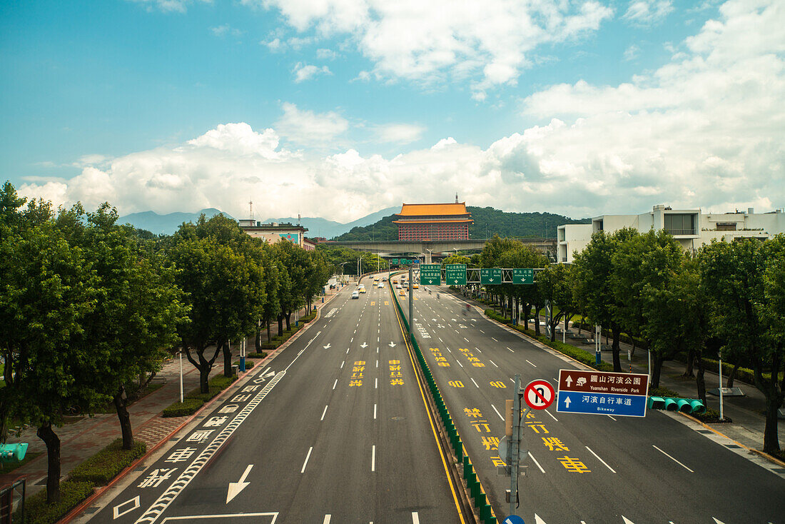 Autos bewegen sich auf der Straße mit Tempel im Hintergrund, Taiwan