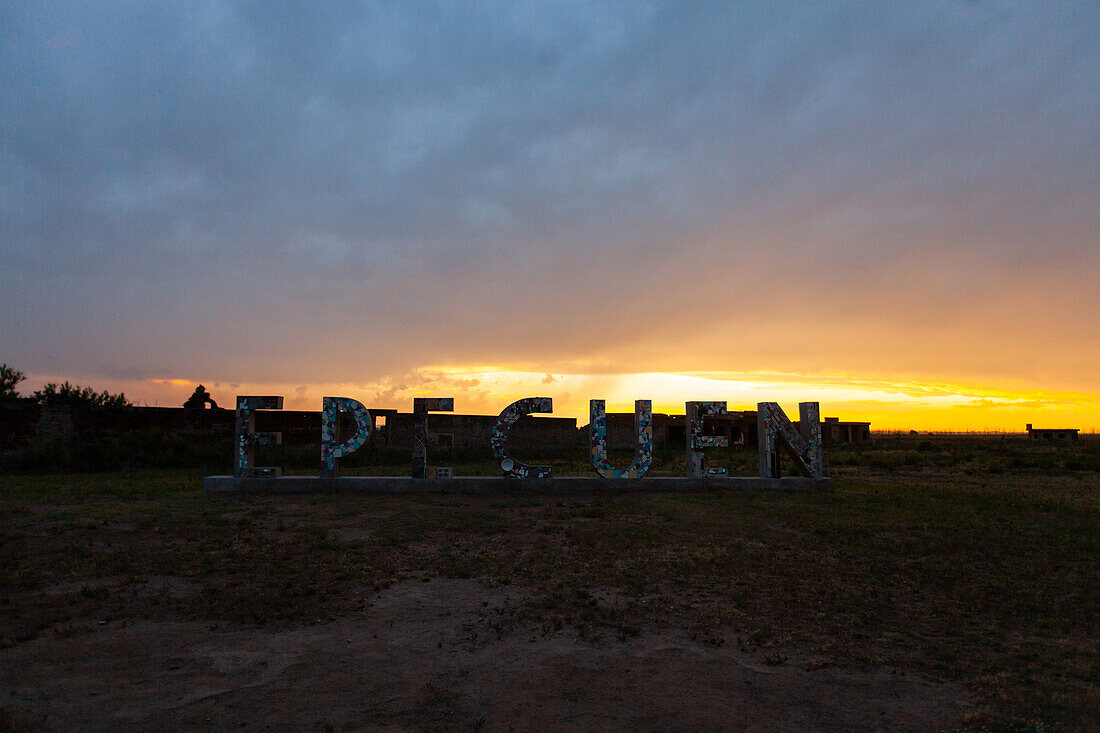 View of text Epecuen on abandoned landscape during sunset