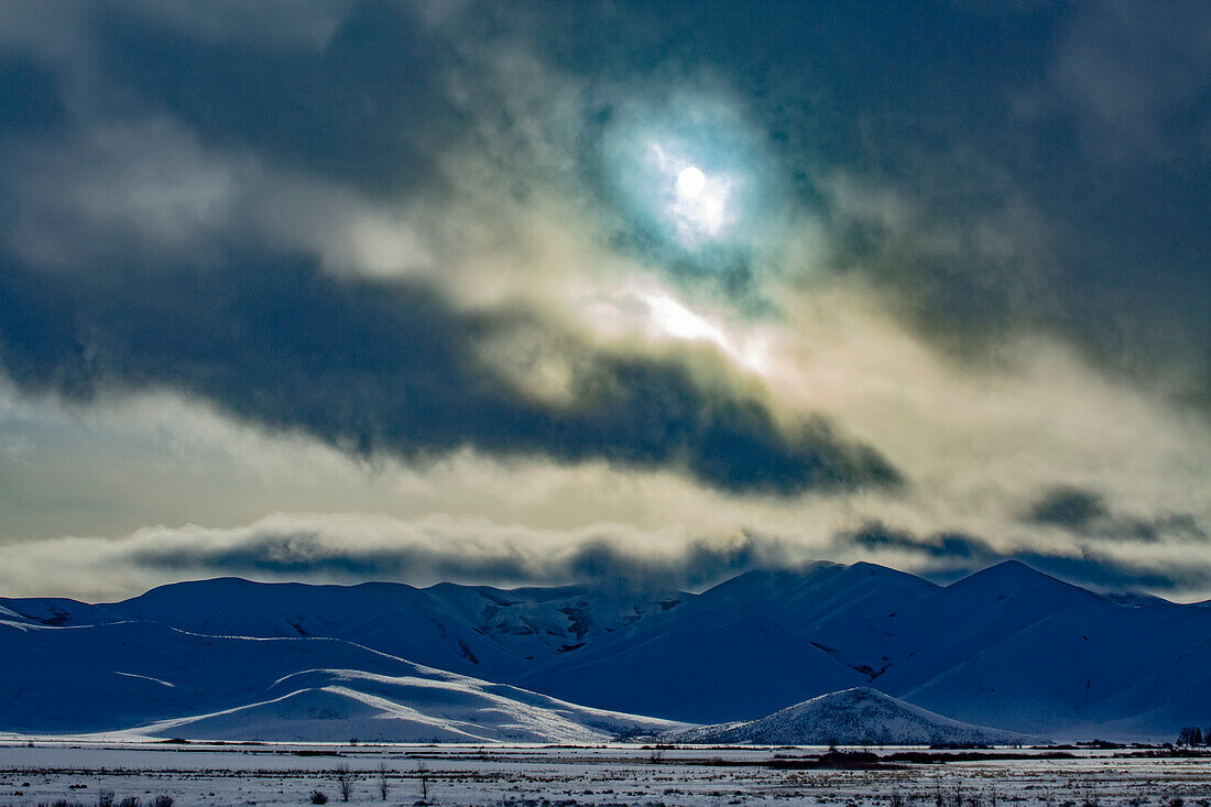 United States, Idaho, Bellevue, Sun shining through clouds above snowcapped mountains