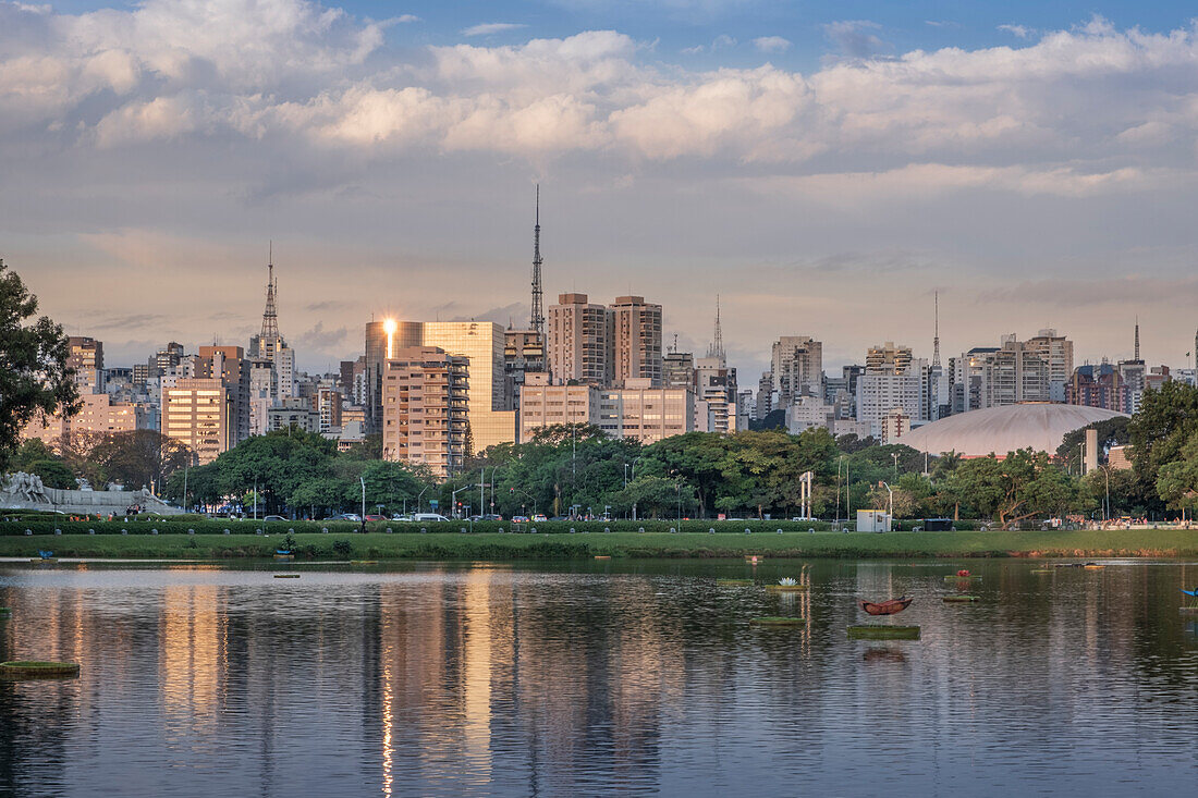 Die Skyline der Innenstadt spiegelt sich in der Dämmerung im See Lago das Garcas wider, Ibirapuera Park, Sao Paulo, Brasilien, Südamerika