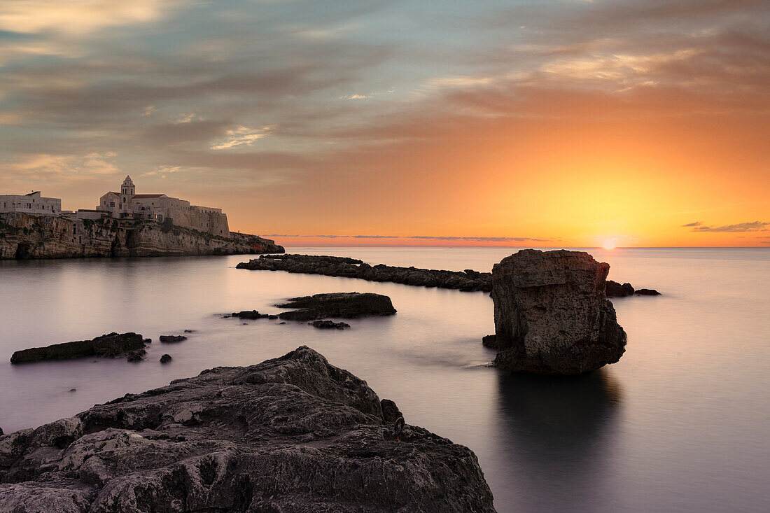 Wolken bei Sonnenaufgang über dem ruhigen Meer rund um Vieste, Provinz Foggia, Nationalpark Gargano, Apulien, Italien, Europa