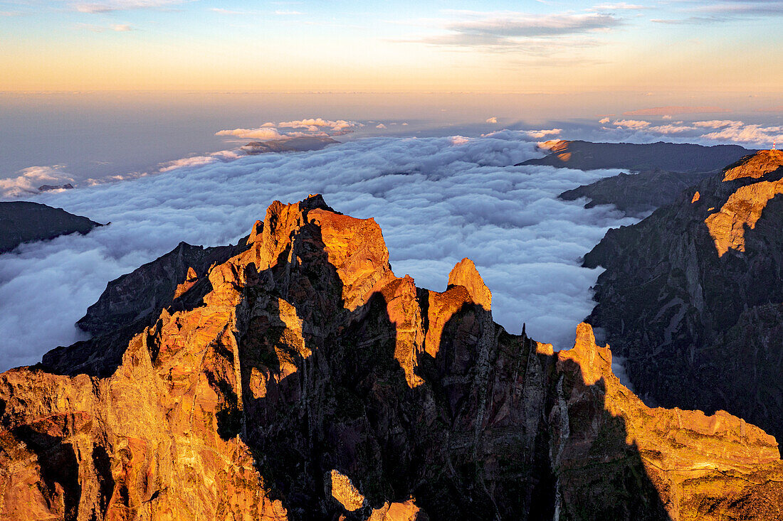 Clouds surrounding the rocky peak of Pico das Torres lit by sunset, Madeira island, Portugal, Atlantic, Europe