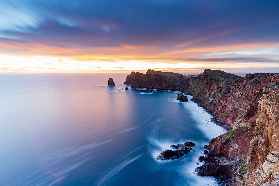 Dramatic sky at dawn on cliffs washed by ocean from Ponta Do Rosto viewpoint, Sao Lourenco Peninsula, Madeira, Portugal, Atlantic, Europe