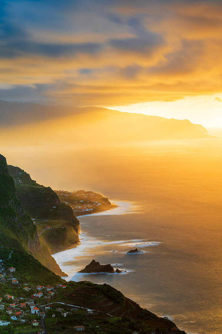 Brennender Himmel bei Sonnenuntergang über den Dörfern Arco de Sao Jorge und Ponta Delgada am Meer, Insel Madeira, Portugal, Atlantik, Europa