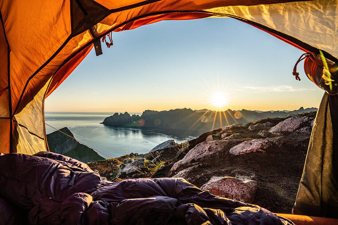 Warme Lichter des Sonnenaufgangs aus dem Inneren des Wanderzeltes, Insel Senja, Troms County, Norwegen, Skandinavien, Europa
