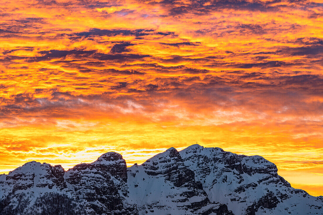 Schneebedeckter Berg Resegone unter dem bunten Himmel bei Sonnenaufgang, Comer See, Provinz Lecco, Lombardei, Italien, Europa