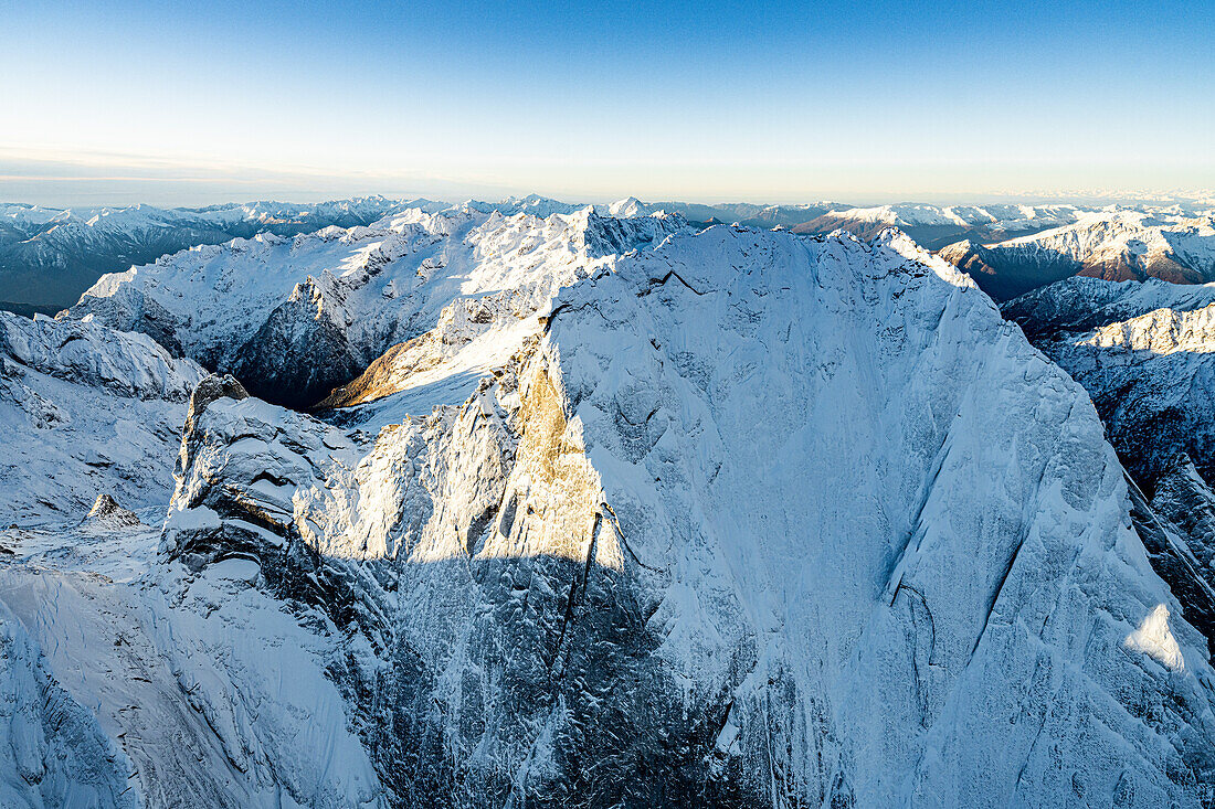 Luftaufnahme der majestätischen Felsen des schneebedeckten Pizzo Badile im Winter, Bergell, Kanton Graubünden, Schweiz, Europa