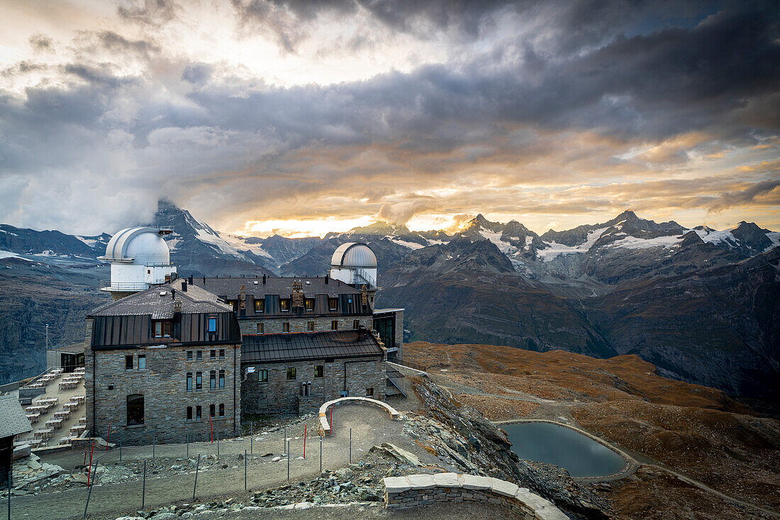 Bewölkter Himmel bei Sonnenuntergang über dem berühmten Kulm Hotel Gornergrat und Matterhorn Peak, Zermatt, Kanton Wallis, Schweizer Alpen, Schweiz, Europa