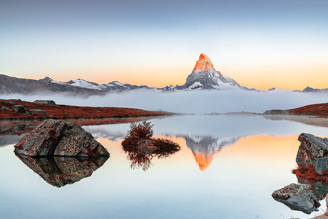 Autumn fog over Matterhorn reflected in the clear water of Stellisee lake at dawn, Zermatt, Valais Canton, Swiss Alps, Switzerland, Europe