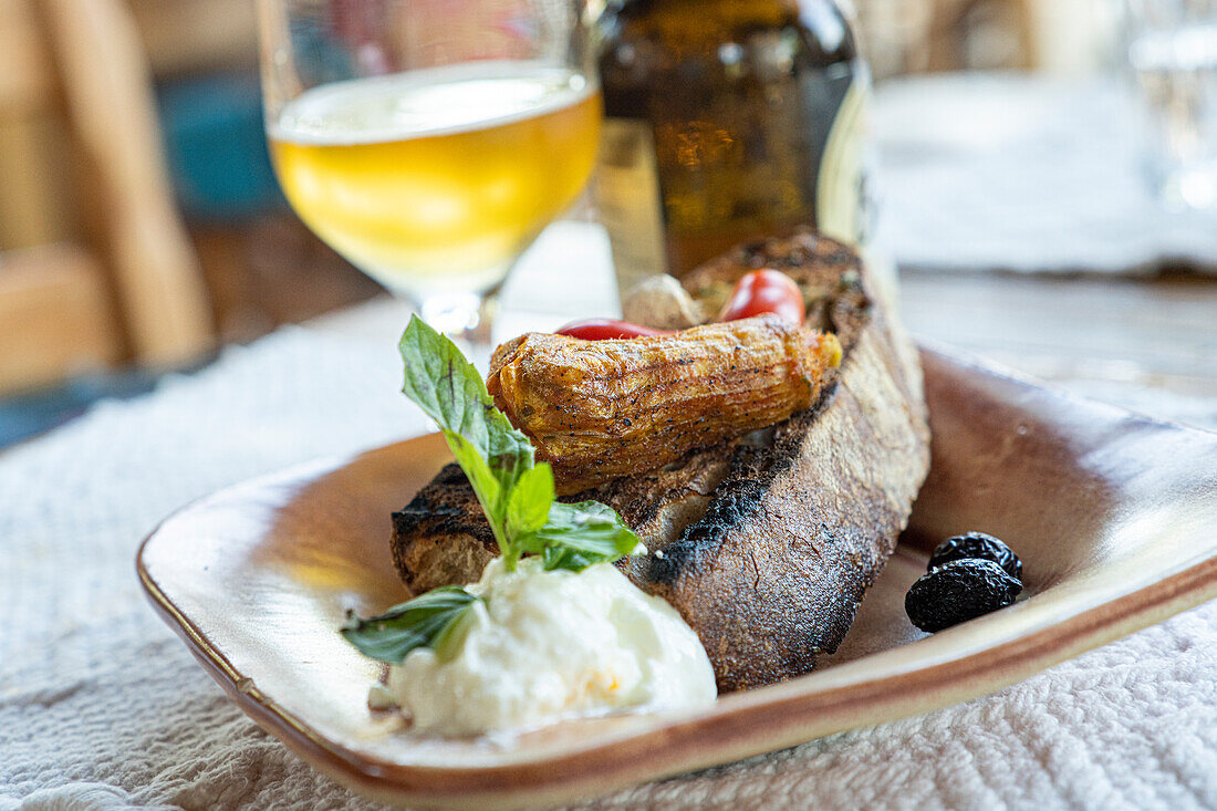 Griechische Vorspeise mit gefüllten Zucchiniblüten, serviert mit Bruschetta und Tzatziki-Sauce in Holzschale, Kreta, griechische Inseln, Griechenland, Europa