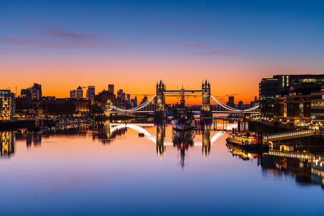 Tower Bridge, HMS Belfast und Reflexionen in einem noch Themse bei Sonnenaufgang, London, England, Vereinigtes Königreich, Europa