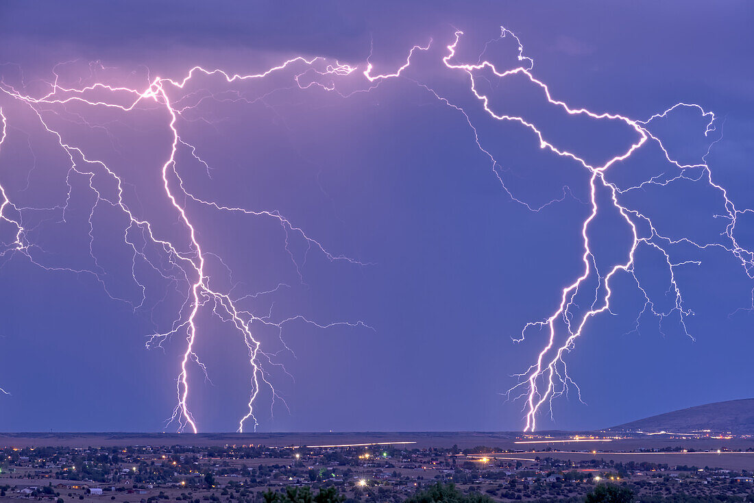 Lightning bolts striking Prescott area in the distance with the town of Chino Valley just north of Prescott Town in the foreground, Arizona, United States of America, North America