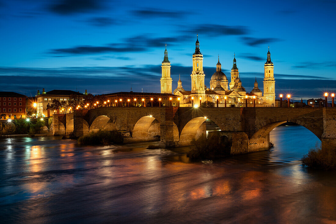 Basilica del Pilar Cathedral with stone bridge crossing Ebro River at night, Zaragoza, Aragon, Spain, Europe