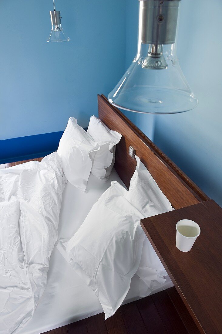 A hotel bed with white bedclothes