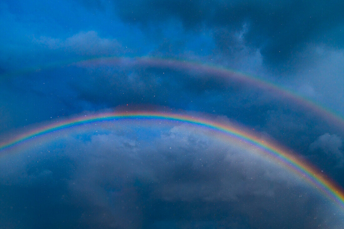 Double rainbow against stormy sky