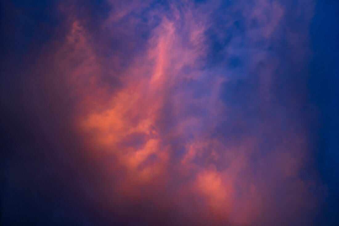 Dramatic pink clouds against dark blue sky