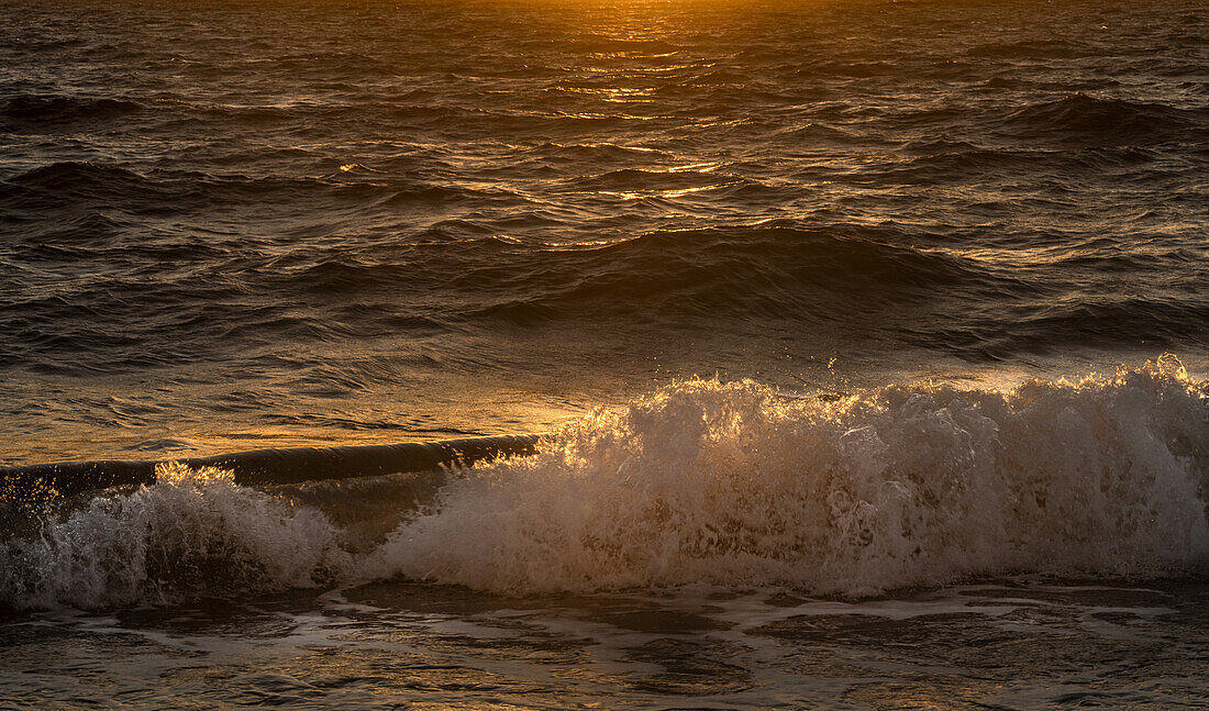 Sea waves splashing at sunrise