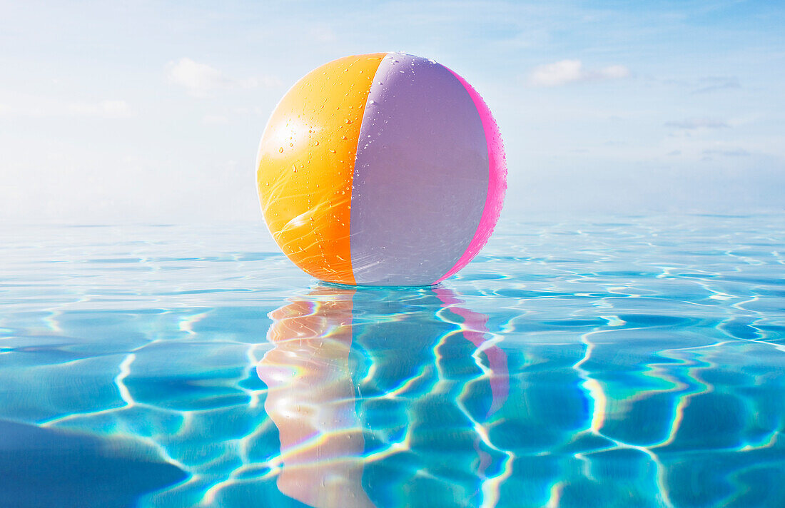 Strandball, der auf ruhiger Wasseroberfläche schwimmt