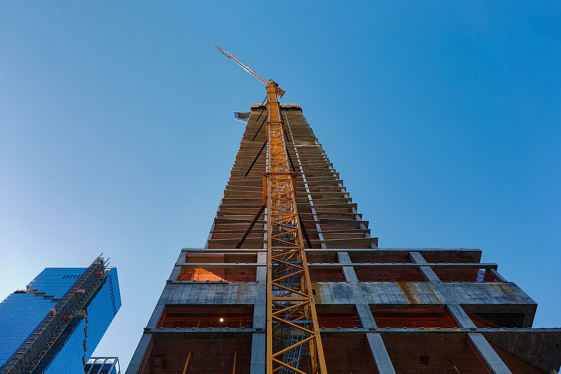 USA, New York, New York City, Low angle view of skyscraper under construction and crane at Hudson Yards