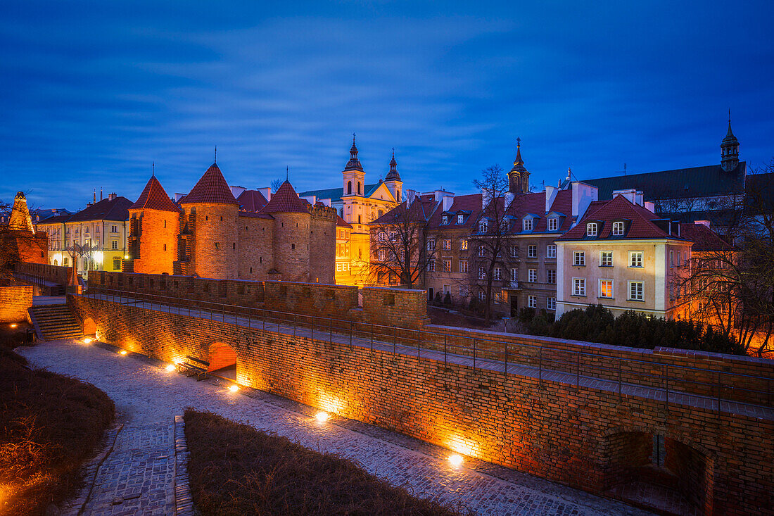 Poland, Masovia, Warsaw, Old City walls and barbican illuminated at night